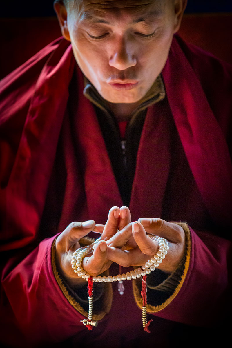 Tibeti buddhista szerzetes mudrát formáz kezeivel (rituális kéztartás) Lamayuru kolostorában, Ladakhban, Indiában.
