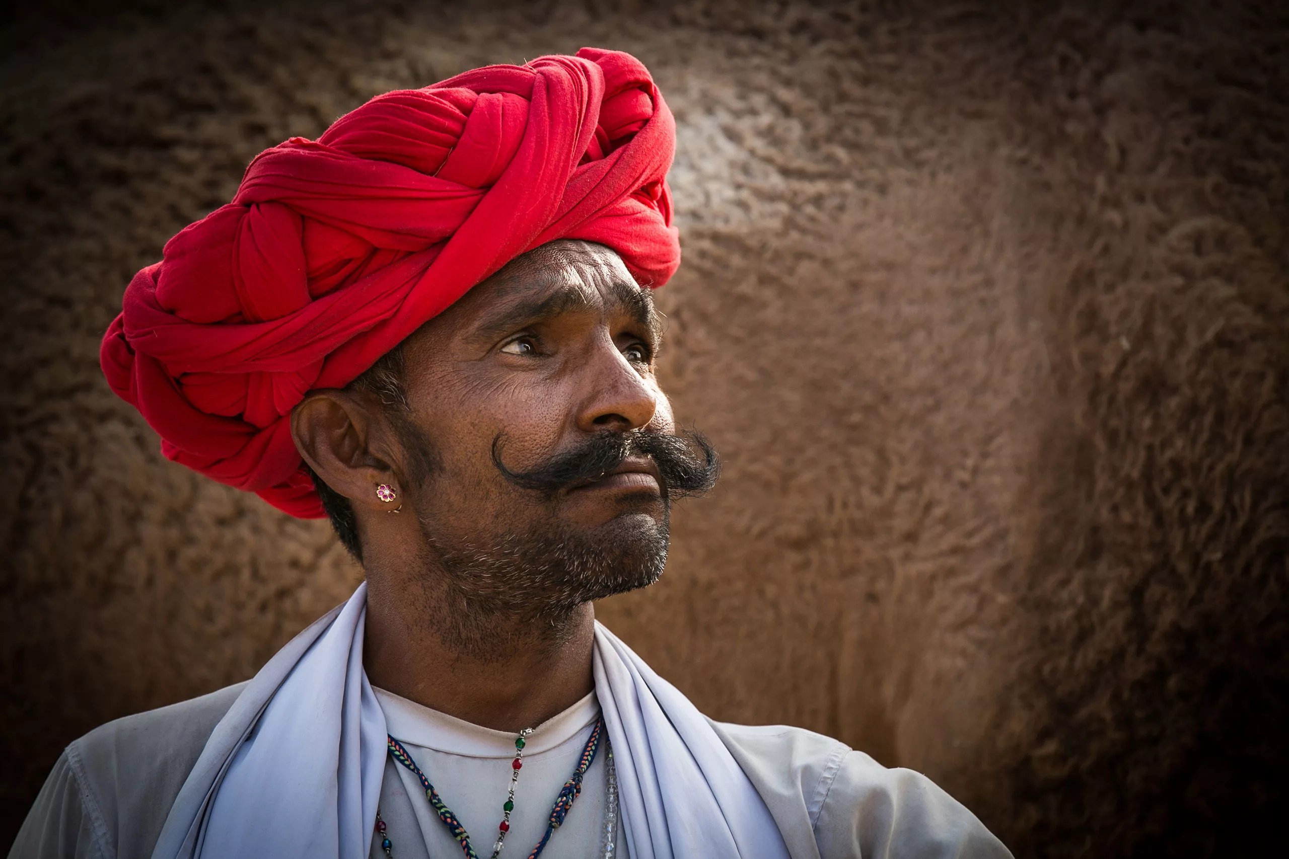Rabari tevepásztor piros turbánban a Pushkar tevevásárban In