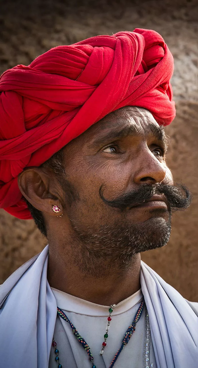 Rabari tevepásztor piros turbánban a Pushkar tevevásárban In