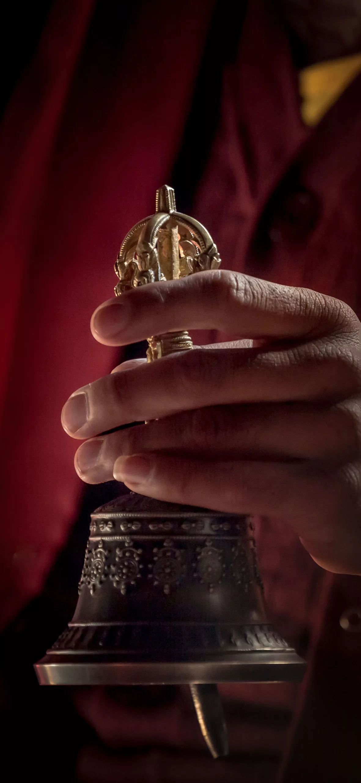 Buddhista szerzetes szertartás közben haranggal a kezében Lad